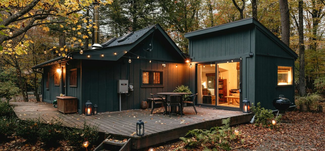 a small cabin with a deck in the woods