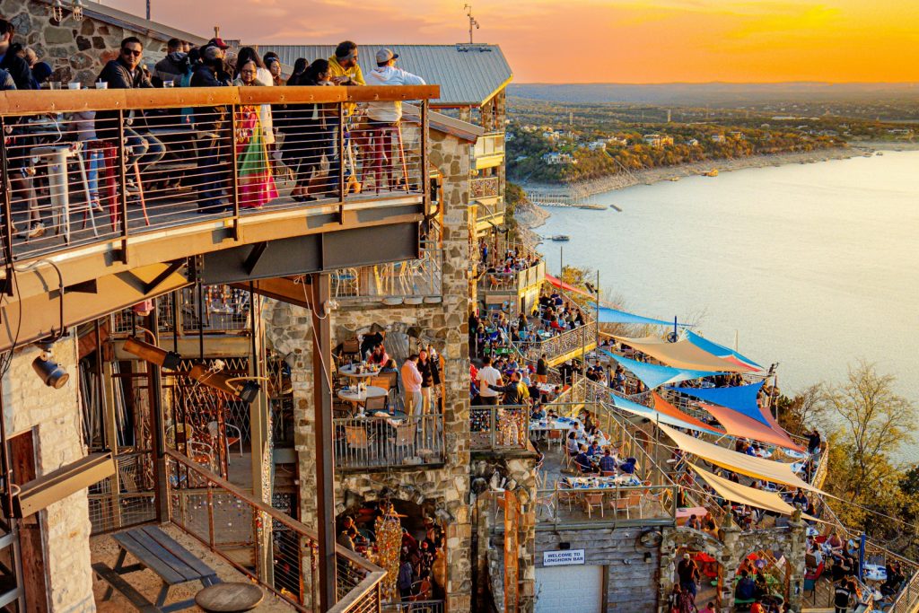 a crowd of people standing on top of a tall building