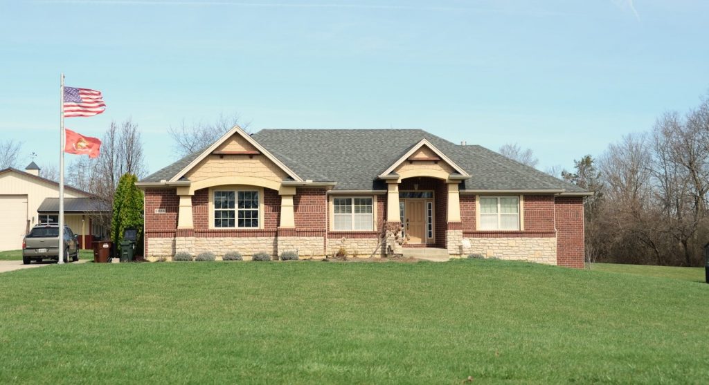 A modern brick house with a large green lawn.