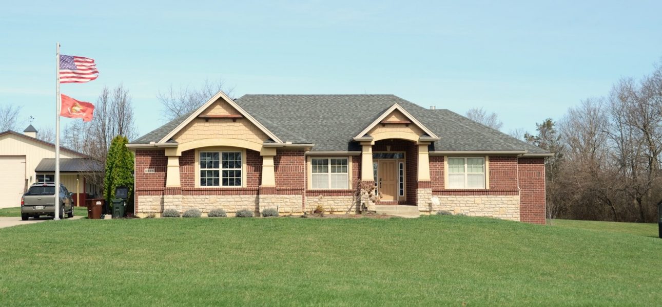 A modern brick house with a large green lawn.