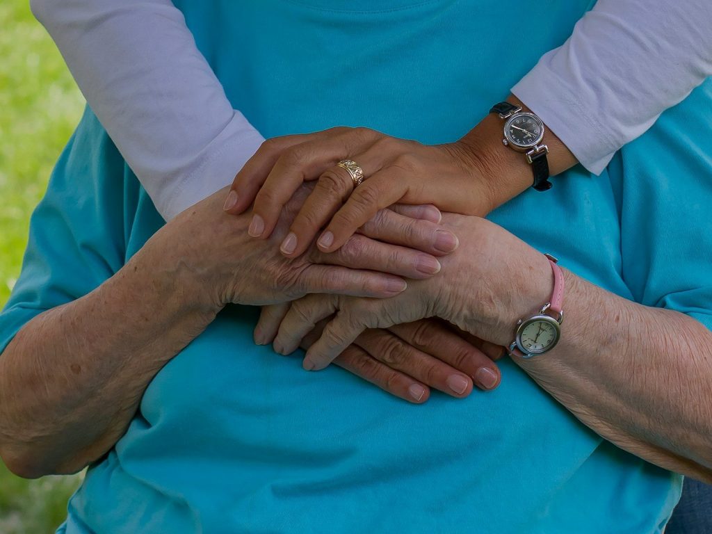 Caregiver holding the hands of an elderly resident