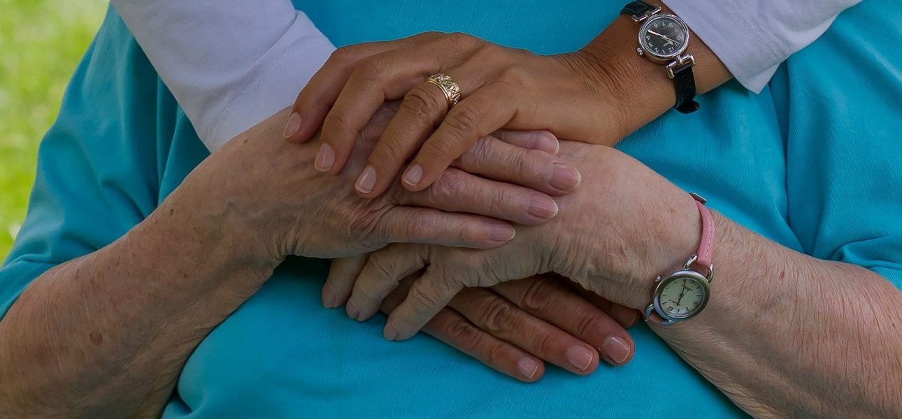 Caregiver holding the hands of an elderly resident