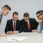 Executives reviewing documents, evaluating transitional real estate lending risk