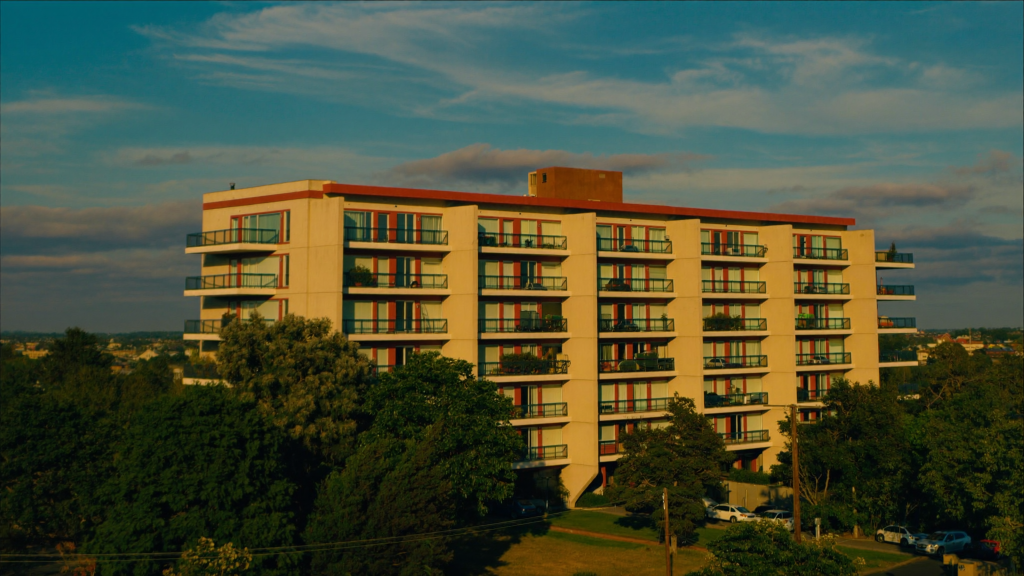 Full-color photo of a modern American mid-rise apartment building at golden hour, representing multifamily bridge financing