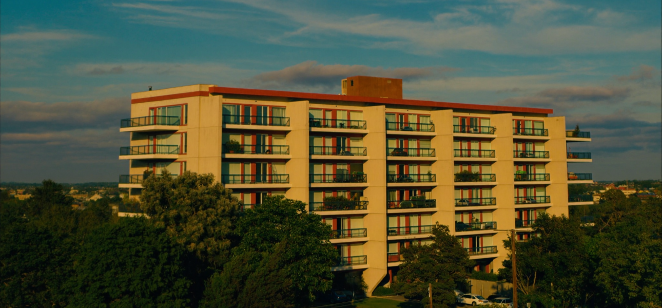Full-color photo of a modern American mid-rise apartment building at golden hour, representing multifamily bridge financing