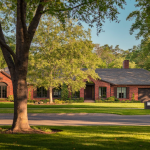 Renovated brick craftsman bungalow home on a tree-lined street in Memphis, Tennessee in late-afternoon light