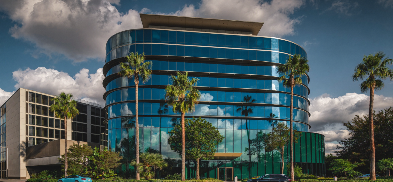 Modern mid-rise office building with blue glass facade and palm trees in Tampa, Florida