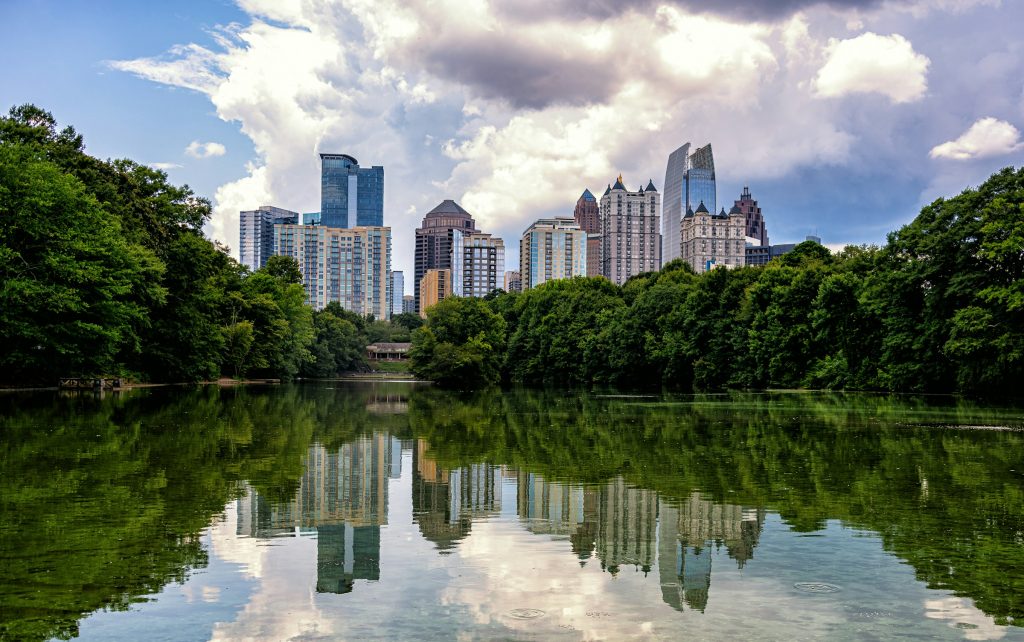 Midtown Atlanta, Georgia skyline reflected in Lake Clara Meer at Piedmont Park under a partly cloudy sky