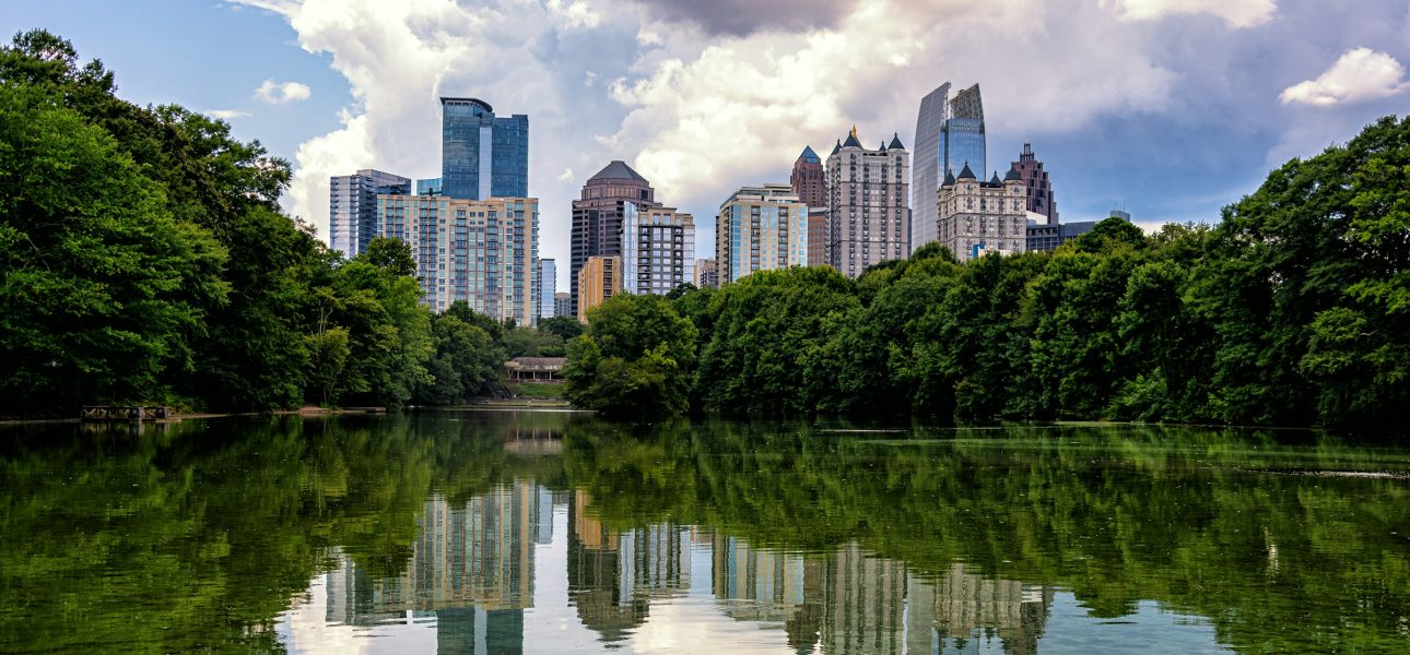 Midtown Atlanta, Georgia skyline reflected in Lake Clara Meer at Piedmont Park under a partly cloudy sky