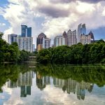 Midtown Atlanta, Georgia skyline reflected in Lake Clara Meer at Piedmont Park under a partly cloudy sky