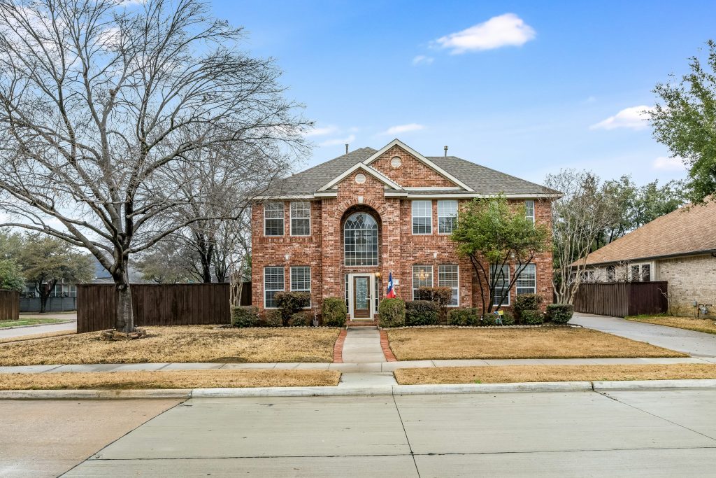Renovated two-story brick single-family home on a Texas suburban street in daylight