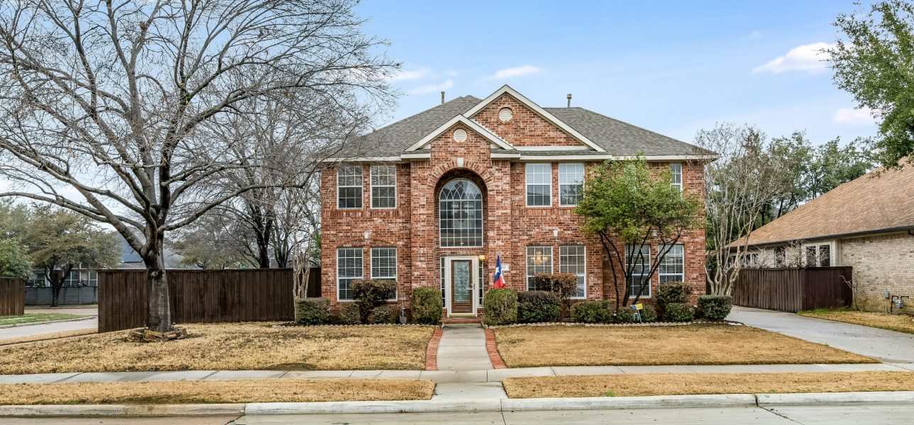 Renovated two-story brick single-family home on a Texas suburban street in daylight
