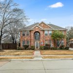 Renovated two-story brick single-family home on a Texas suburban street in daylight