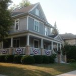 Two-story American house with front porch and flag bunting