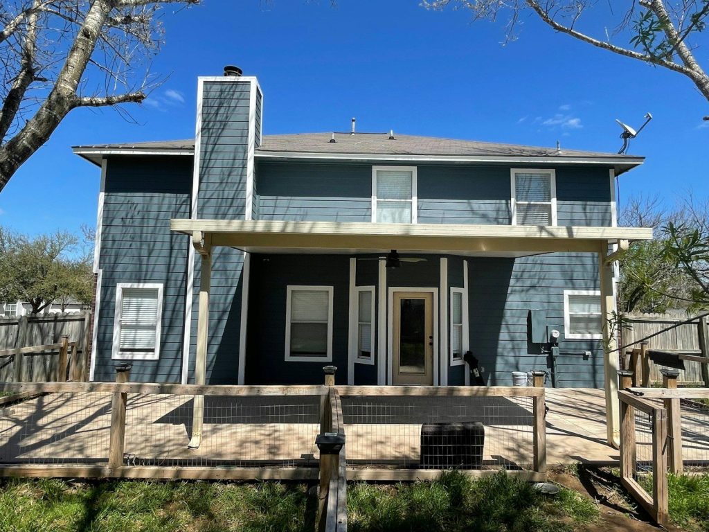 Two-story blue house with deck in Central Texas