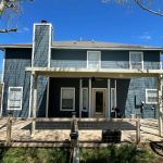 Two-story blue house with deck in Central Texas